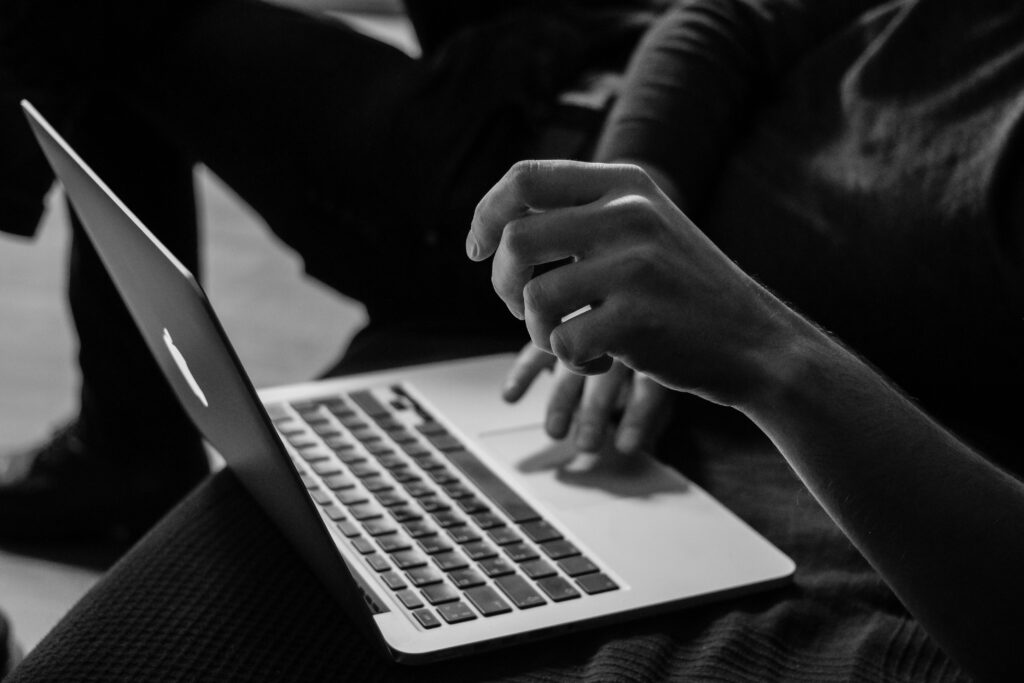 Close-up of person using a laptop, focused on hand and keyboard
