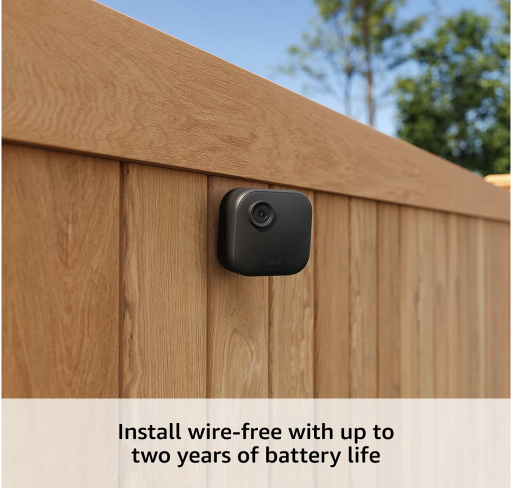 Blink Outdoor 4 camera mounted on a wooden fence, highlighting wire-free installation and two-year battery life