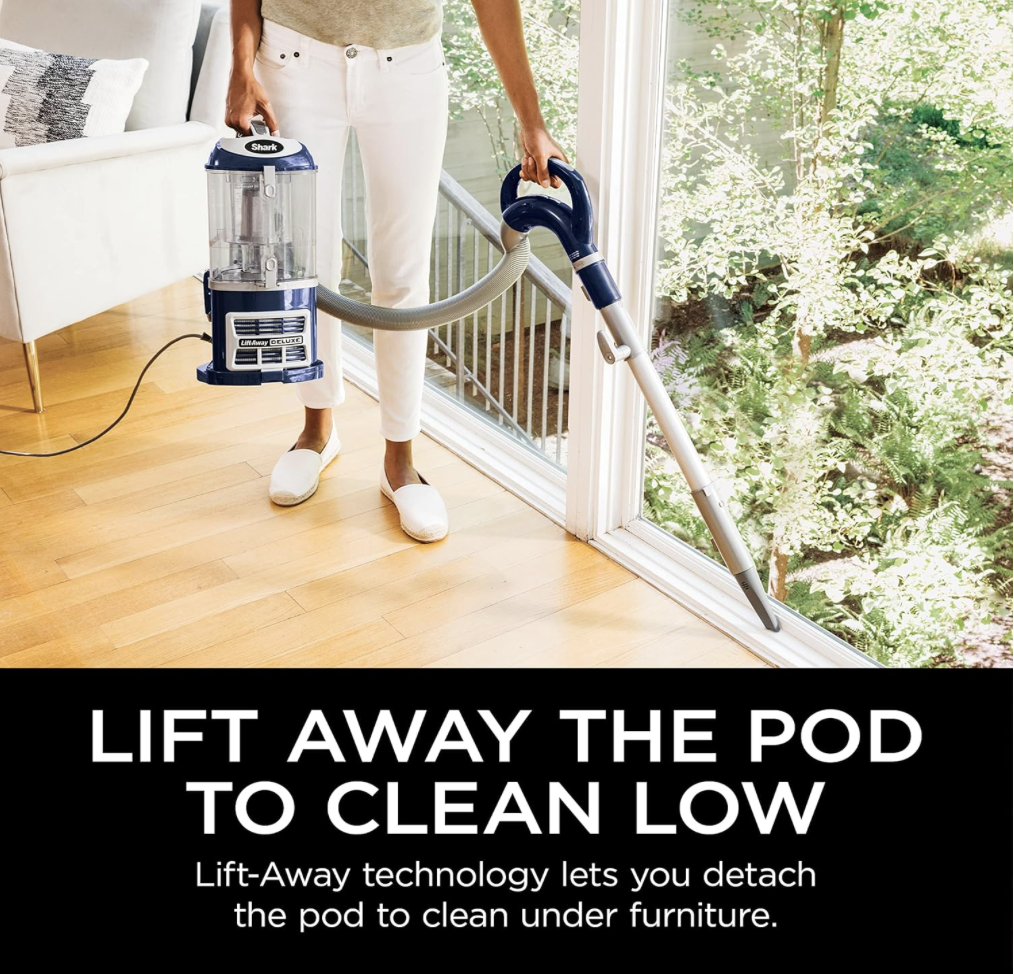 Person using the Shark NV360's lift-away pod feature to clean low areas under furniture on hardwood flooring.
