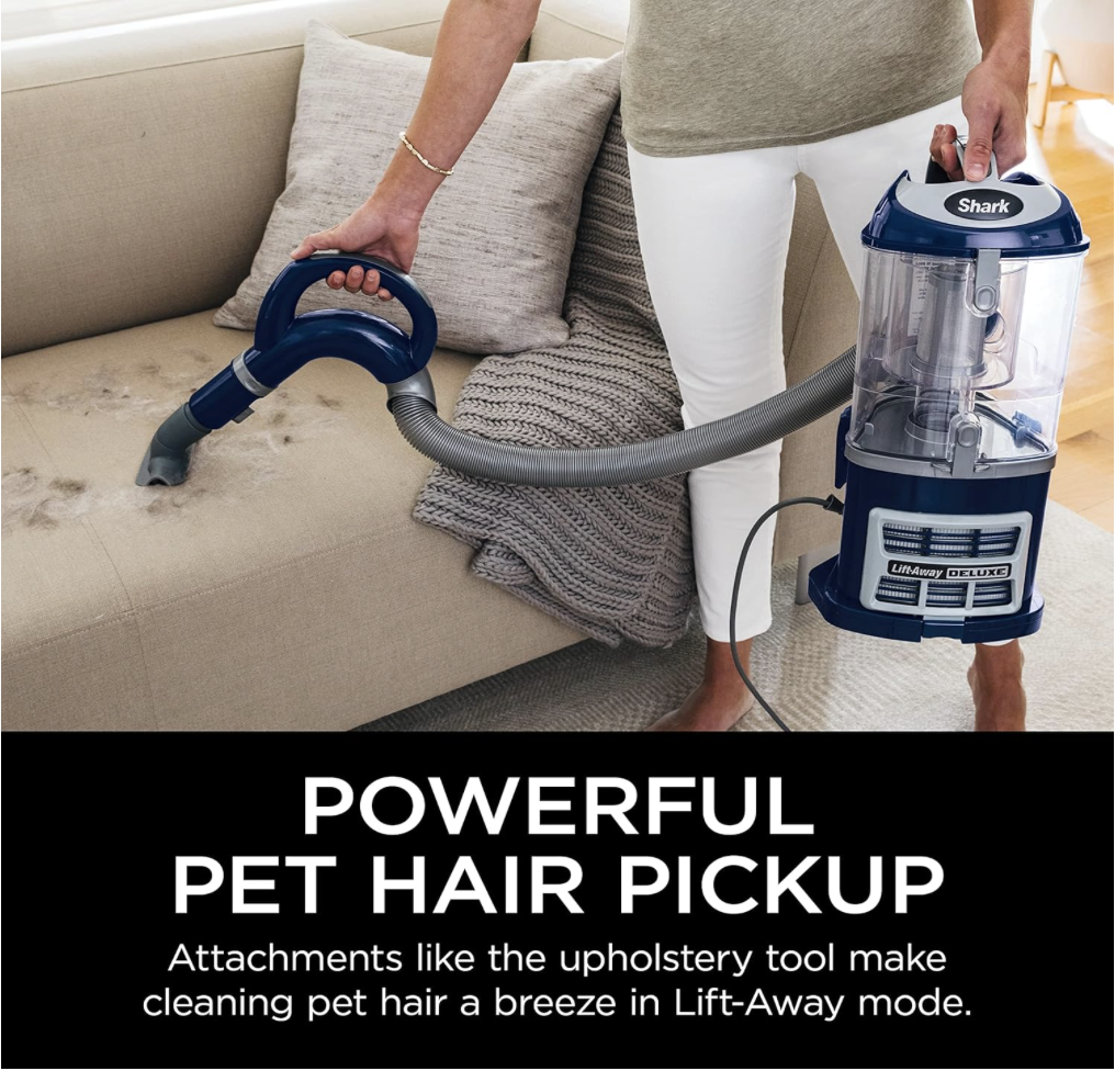 Close-up of the Shark NV360 vacuum cleaning pet hair off a fabric sofa using the upholstery tool in Lift-Away mode.