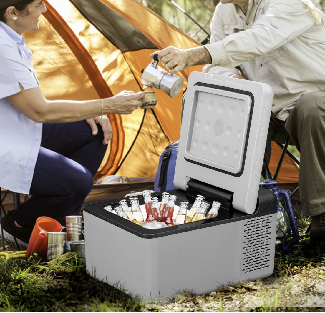 VEVOR 10 Quart portable car fridge filled with bottled drinks and ice, placed near a camping tent while two people enjoy coffee outdoors.