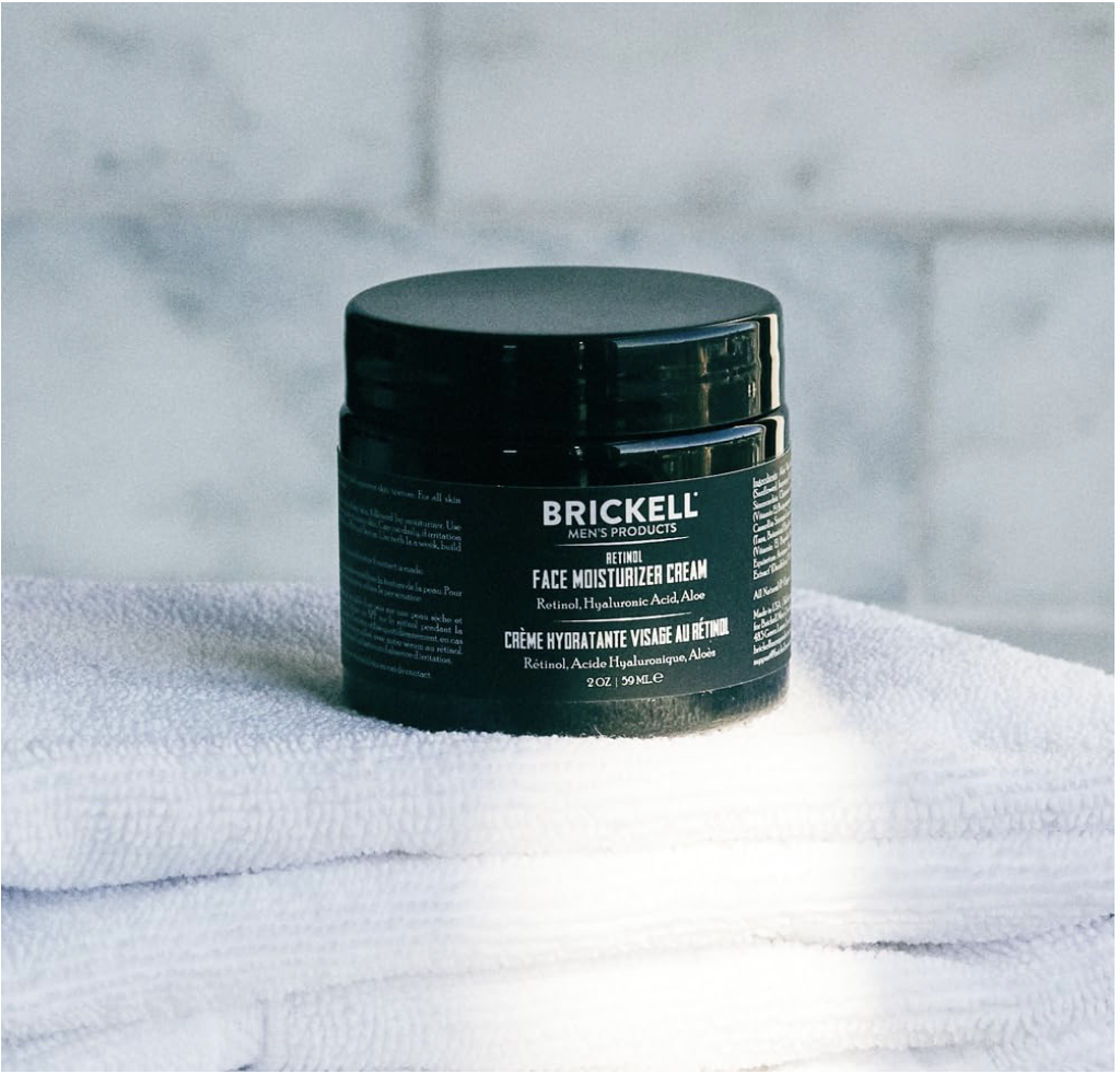 Brickell Men’s Retinol Face Moisturizer Cream jar placed on folded white towels in a bathroom setting.