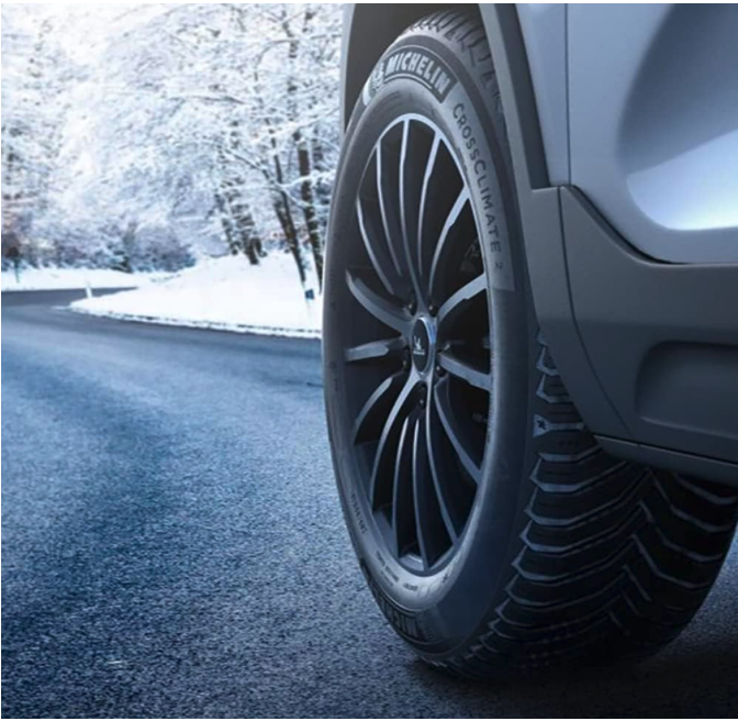 Vehicle driving on a snowy road equipped with MICHELIN CrossClimate2 tires, demonstrating all-season and winter traction.